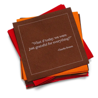 Stack of red, orange, and brown organic cotton cocktail napkins with the printed quote, “What if today, we were just grateful for everything?” – Charlie Brown.