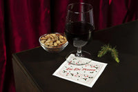 Organic cotton cocktail napkin with 'Tis The Season' quote, glass of red wine, bowl of nuts