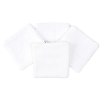 Set of four white organic cotton square pads with soft textured surface, arranged in a fan
