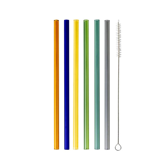 Six straight glass straws in orange, blue, yellow, green, teal, and grey with a cleaning brush, flat lay on a white background.