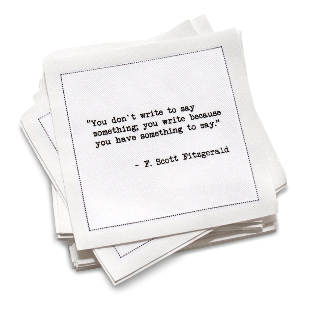 Stack of white cotton cocktail napkins with black text quote by F. Scott Fitzgerald on a white background