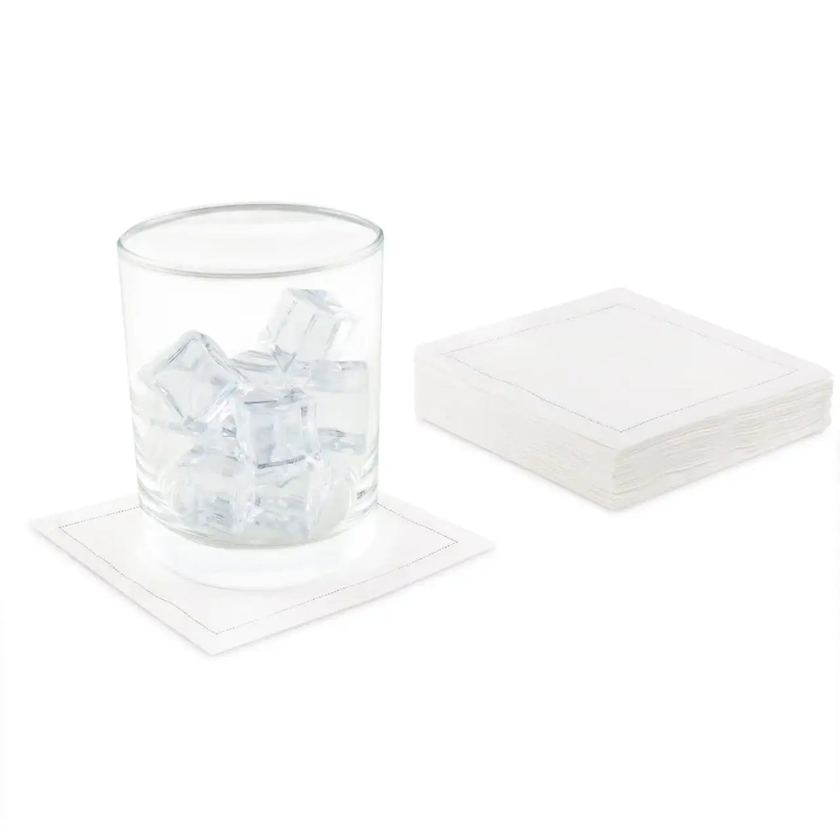 White Signature organic cotton cocktail napkins, one under a glass with ice, stacked pack beside