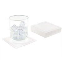 White Signature organic cotton cocktail napkins, one under a glass with ice, stacked pack beside