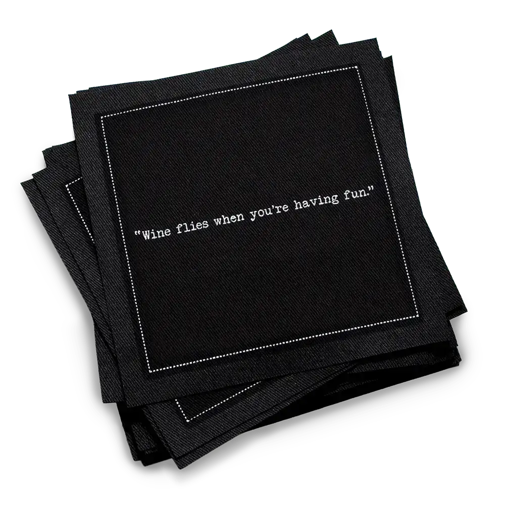 Organic cotton cocktail napkin, black, with white dotted border printed with the quote "Wine flies when you're having fun," from Five Star Napkins' Wine quote collection